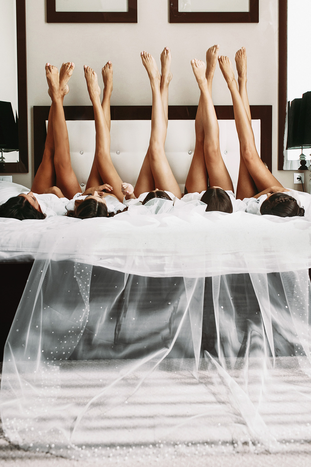 Beautiful bride & bridesmaids showing off sexy legs on bed | Q Nails & Spa